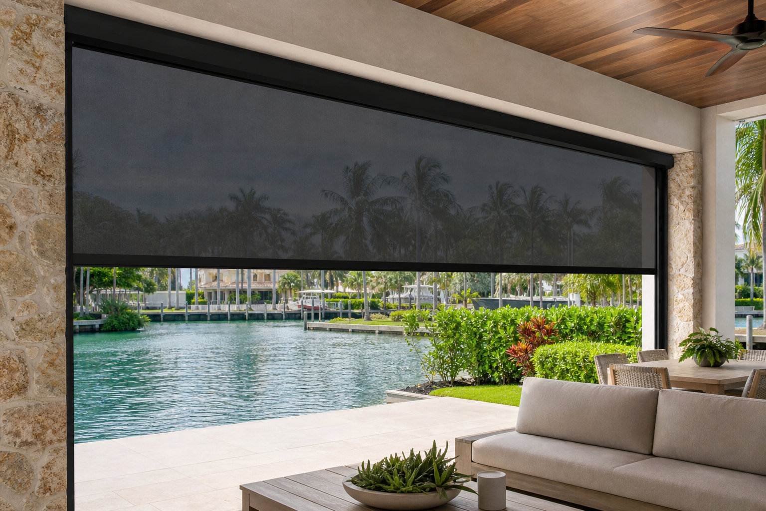 Motorized outdoor screen lowered over a waterfront patio at a South Florida home